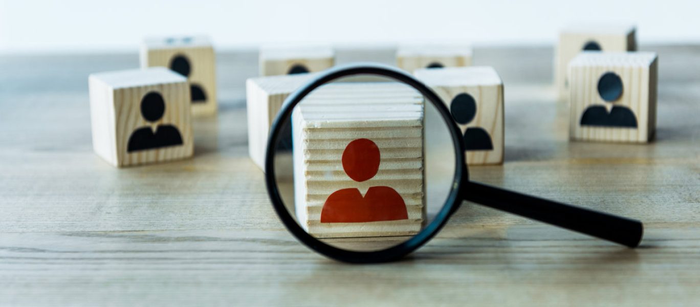 selective focus of magnifying glass near cubes on wooden desk